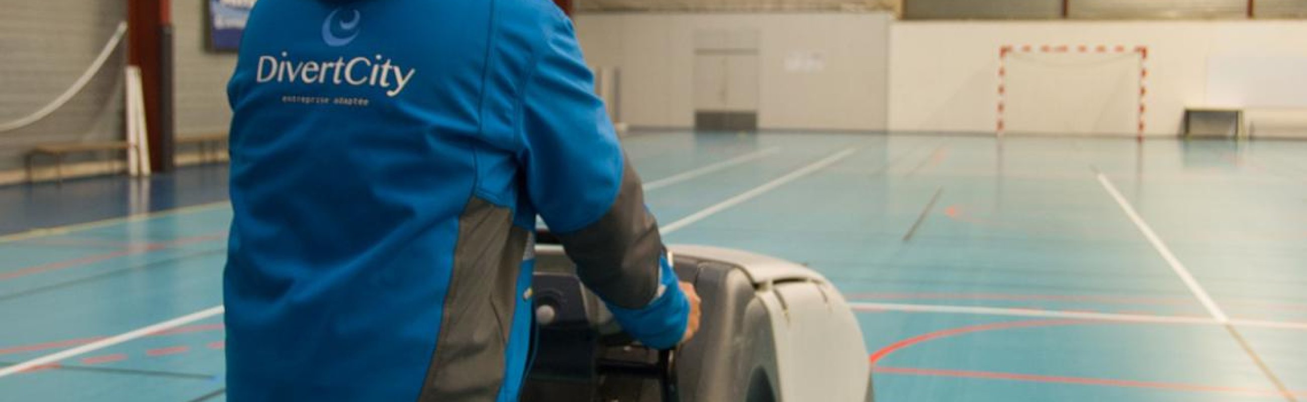 Un salarié en bleu avec une autolaveuse